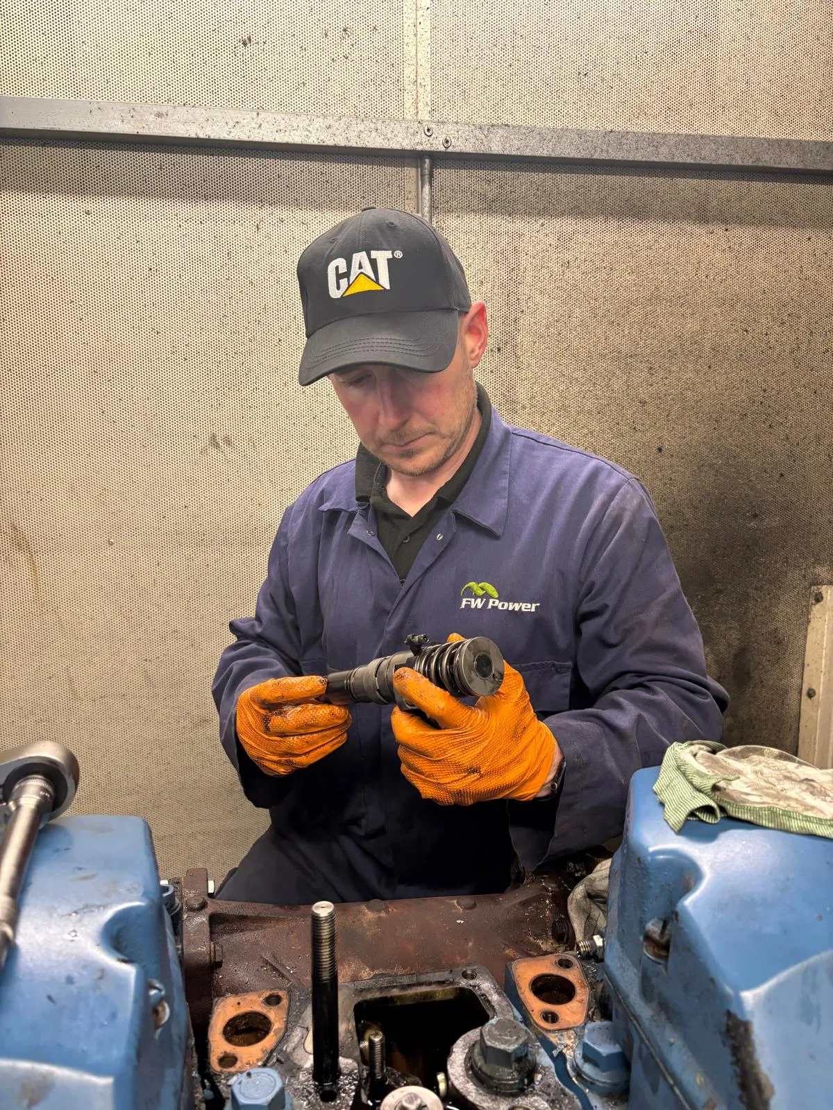 FW Power engineer examining a removed engine component in Telford