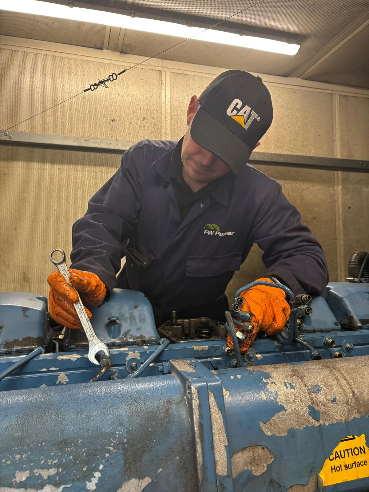 FW Power engineer using hand tools on the engine during remedial works in Telford