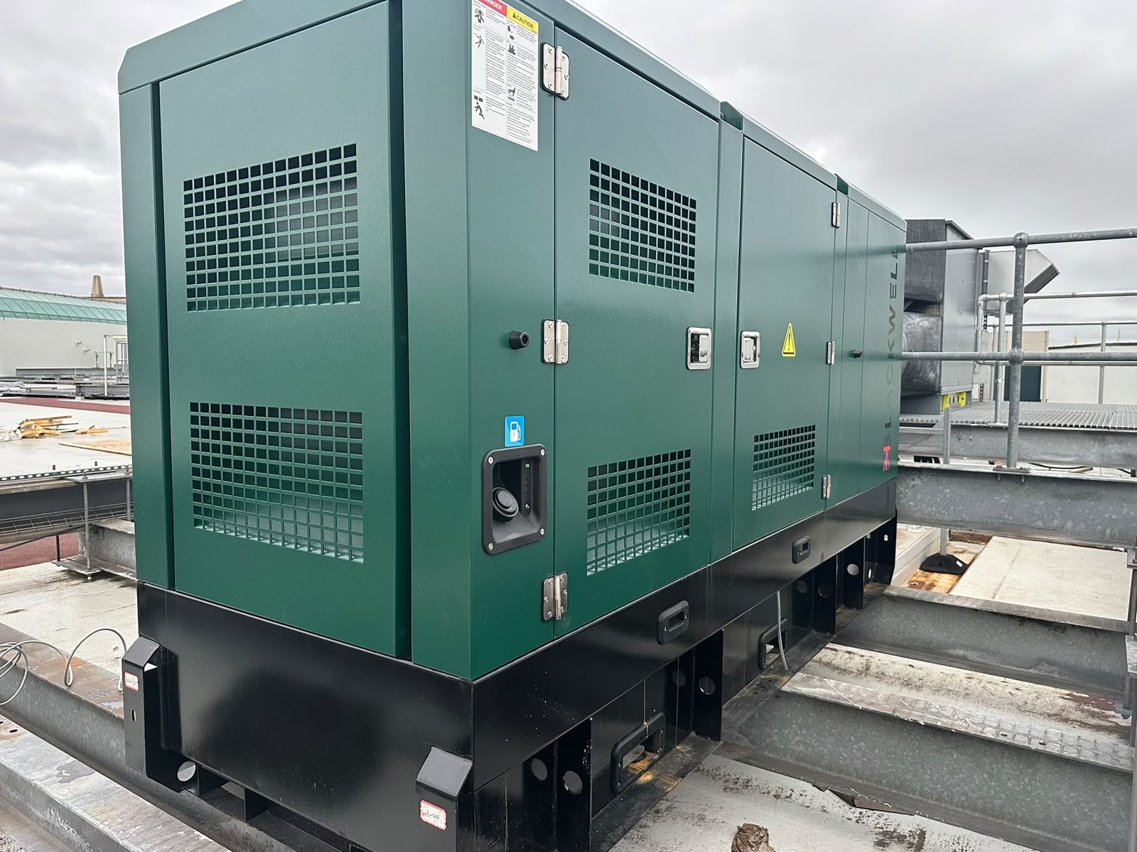 Side and rear view of the green Blackwell B110LS enclosure, showing ventilation grilles and access doors.