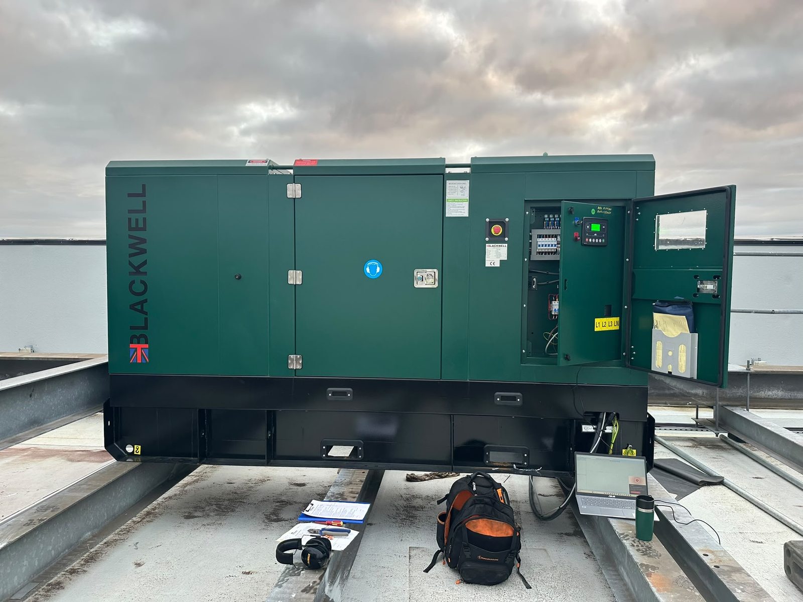 Blackwell generator with its control panel open, beside a laptop and tools during commissioning at the Trafford Centre.