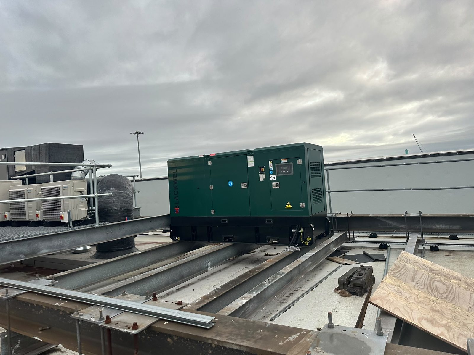 Wide view of the Blackwell diesel generator on rooftop steel supports beside plant equipment at the Trafford Centre.